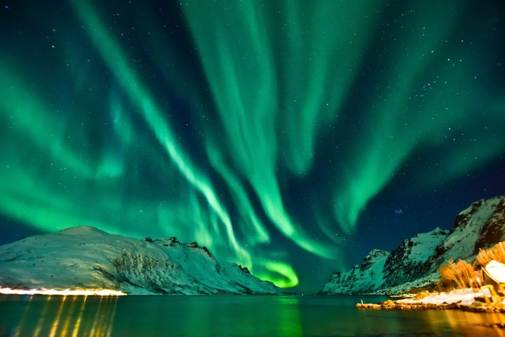 northern lights over fjord in tromso, one of the best snowy places to go in europe winter