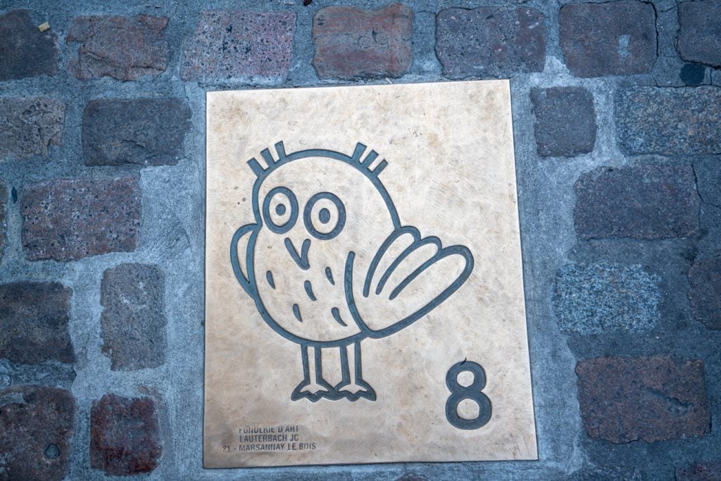 small bronze owl placard on the ground marking one of the best things to see in dijon france