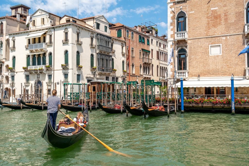 gondola being steered a across the grand canal, a memorable sight on an itinerary for venice in 2 days