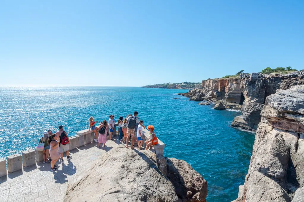 travelers overlooking the sea at boca do inferno, one of the best things to do in cascais day trip