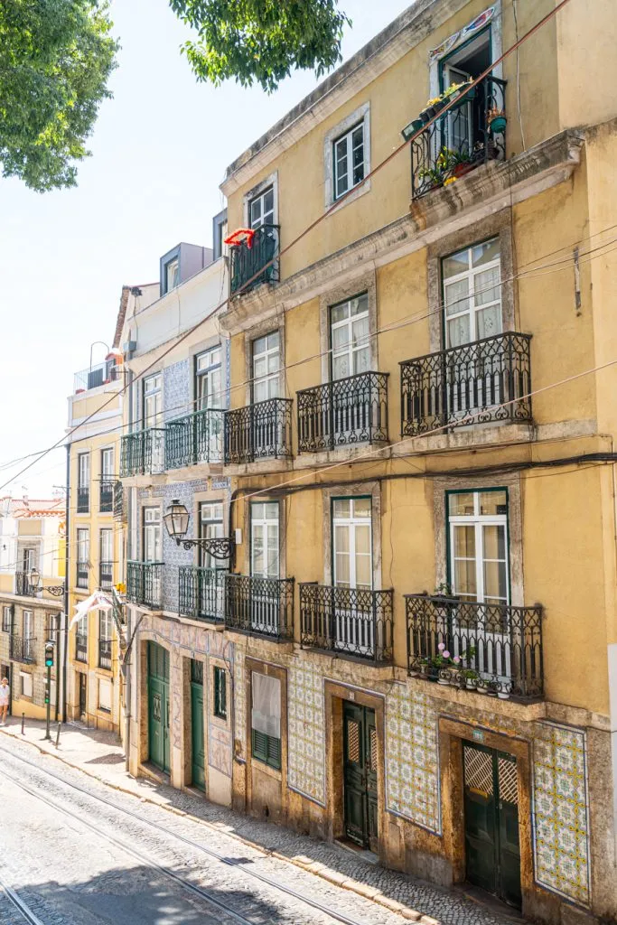 colorful buildings with iron balconies in graca lisbon, as seen when traveling portugal