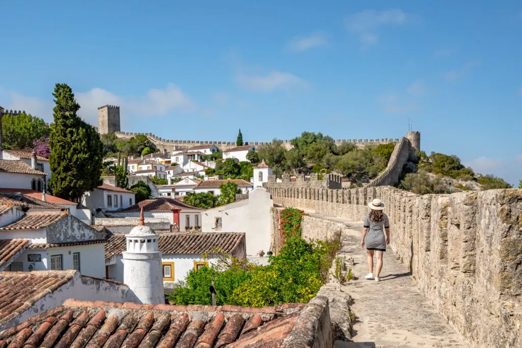 kate storm walking along the castle walls, one of the best things to do in obidos portugal