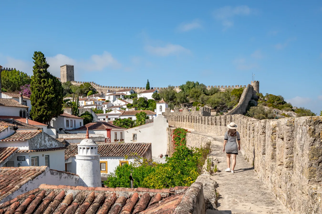 kate storm walking along the castle walls, one of the best things to do in obidos portugal
