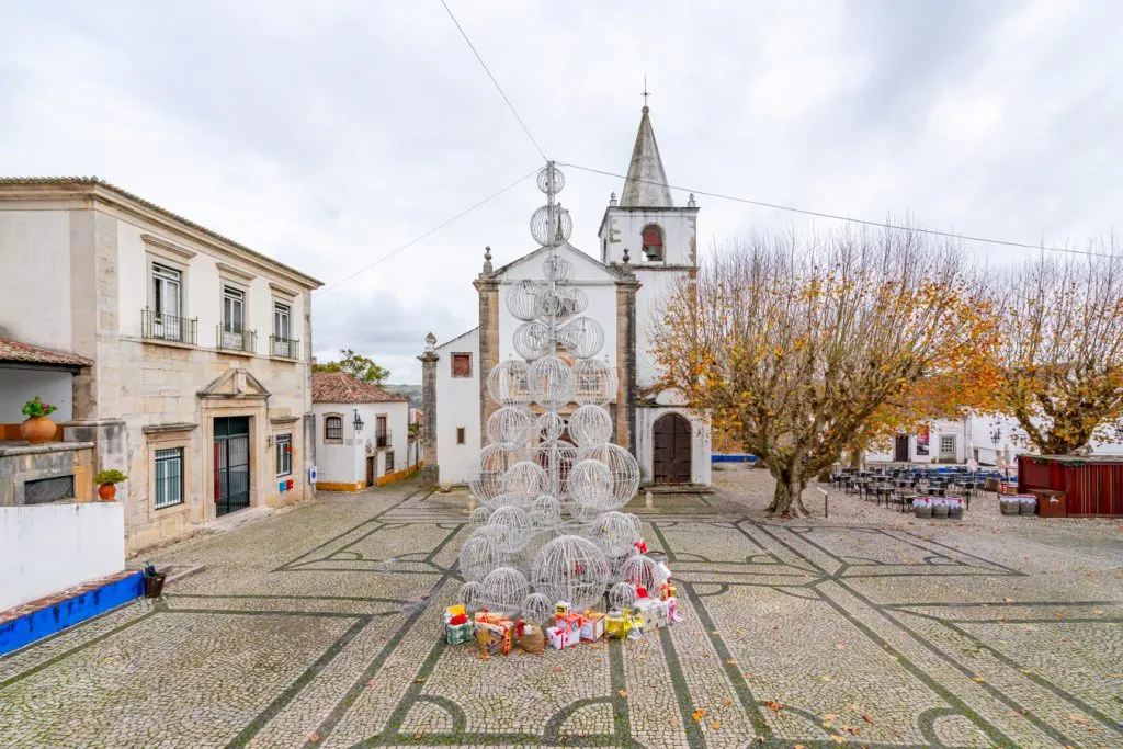 christmas tree in front of a church in obidos, one of the best things to do in portugal winter