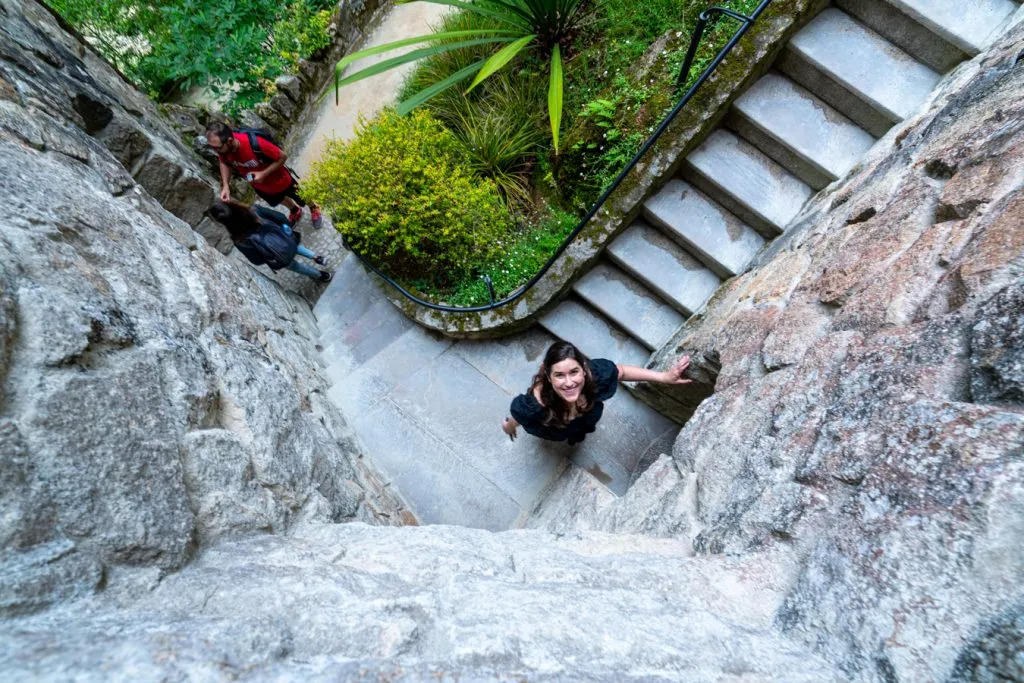 kate storm smiling when looking up a stone tower in sintra portugal