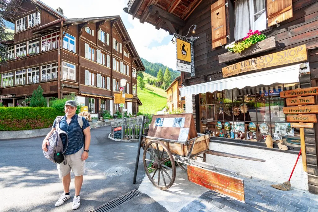 jeremy storm standing in front of the honesty shop in gimmelwald switzerland