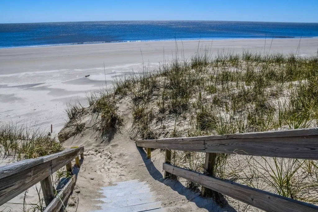 wooden staircase leading to a sandy empty beach jekyll island ga