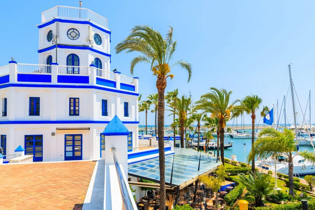 white and blue lighthouse at the harbor in estepona