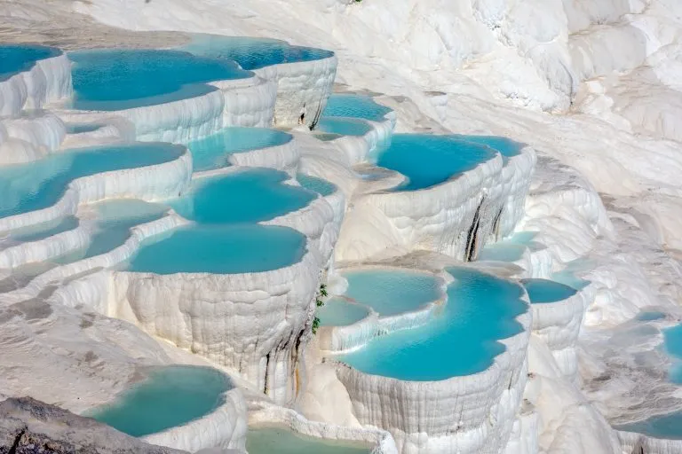 travertine terraces of pamukkale filled with bright blue water, one of the prettiest places to visit in turkey