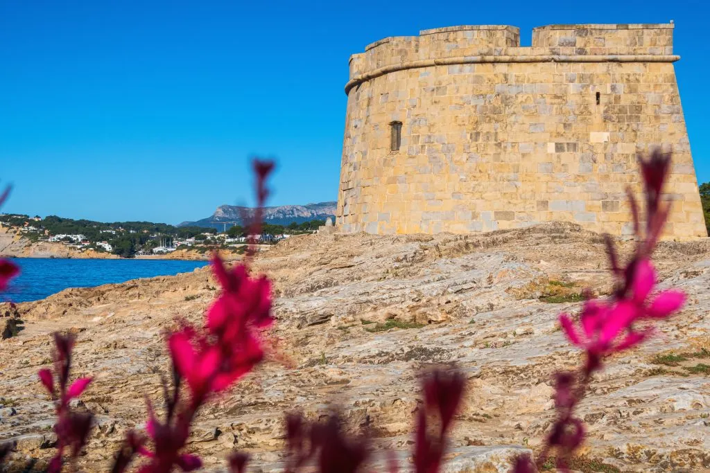 moraira castle with pink flowers in the foreground