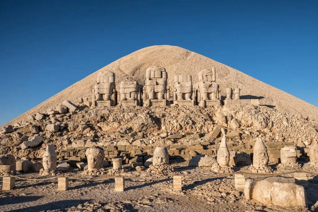 antique statues with mount nemrut in the background, one of the most interesting things to see in turkey