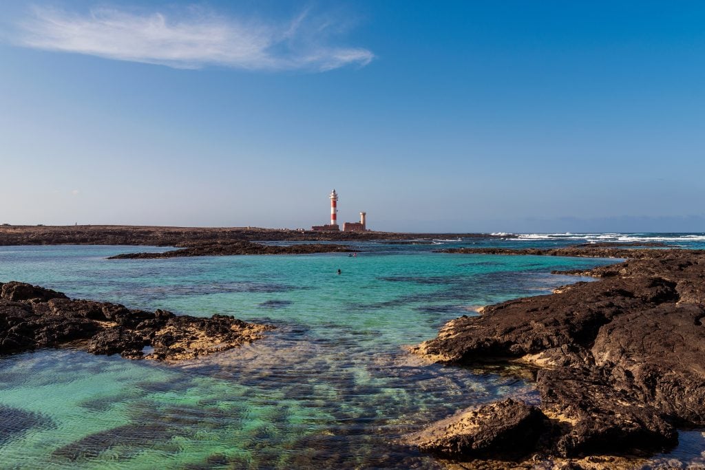el cotillo lighthouse with turquoise water in front of it in el cotillo, one of the best beach towns in spain