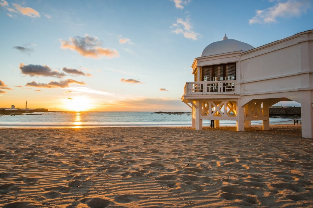 cadiz beach with pier at sunset