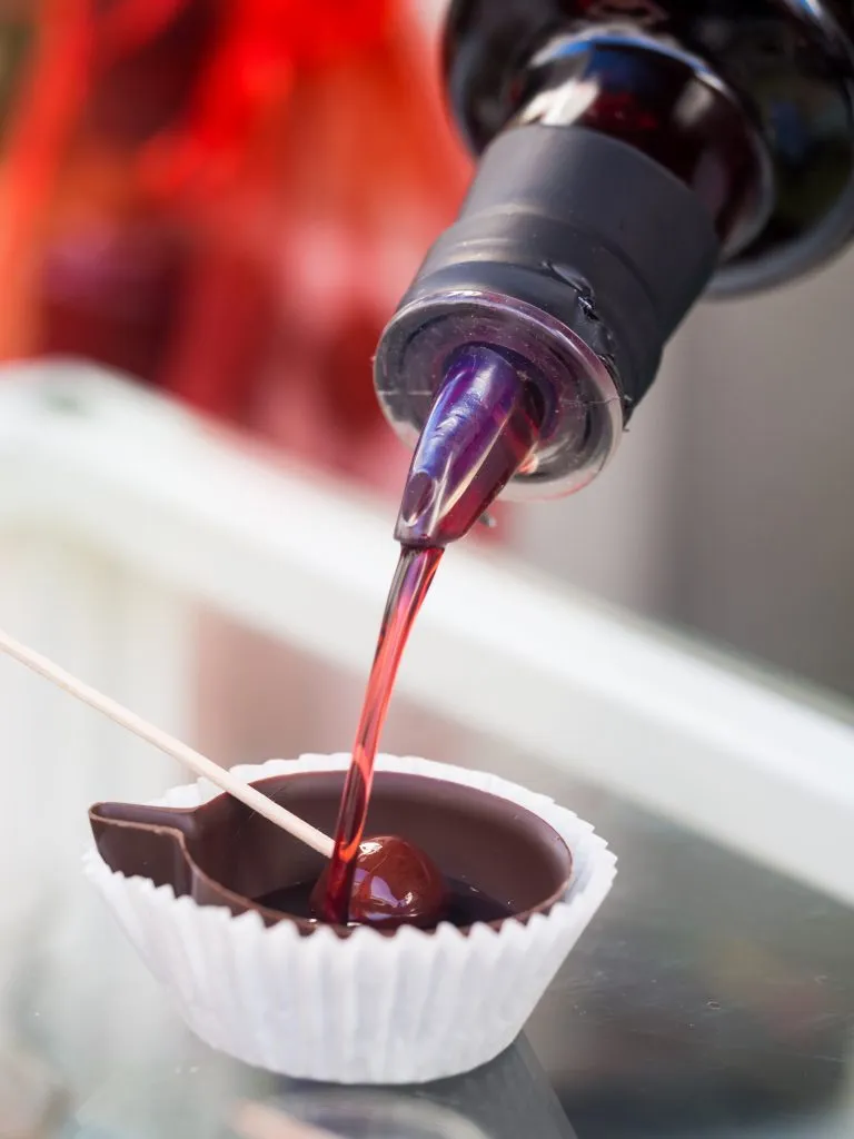 ginjinha de obidos being poured into a chocolate cup