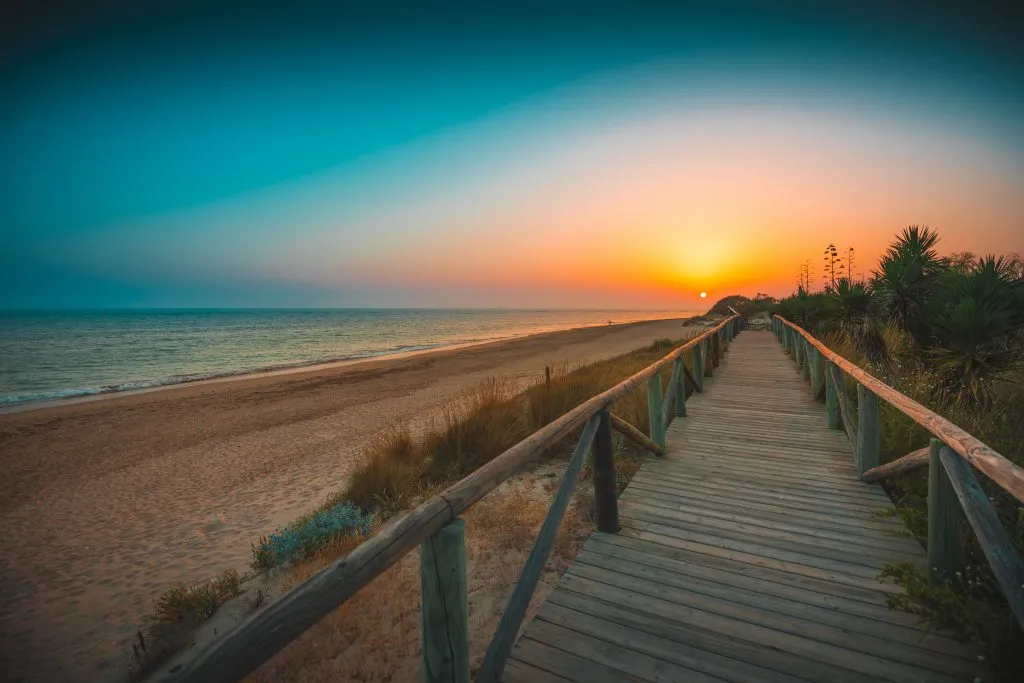 wooden boardwalk along the sandy beach in rota at sunset