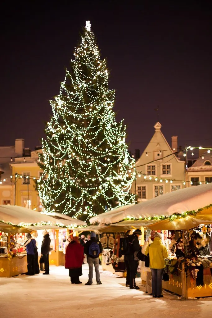 tallinn christmas fair at night with large tree in center, one of the best places to celebrate christmas in europe