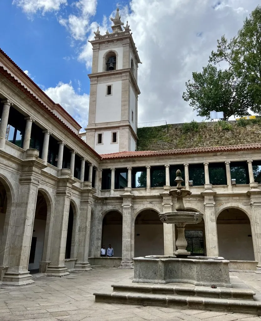 cloisters with a white bell tower visible behind them