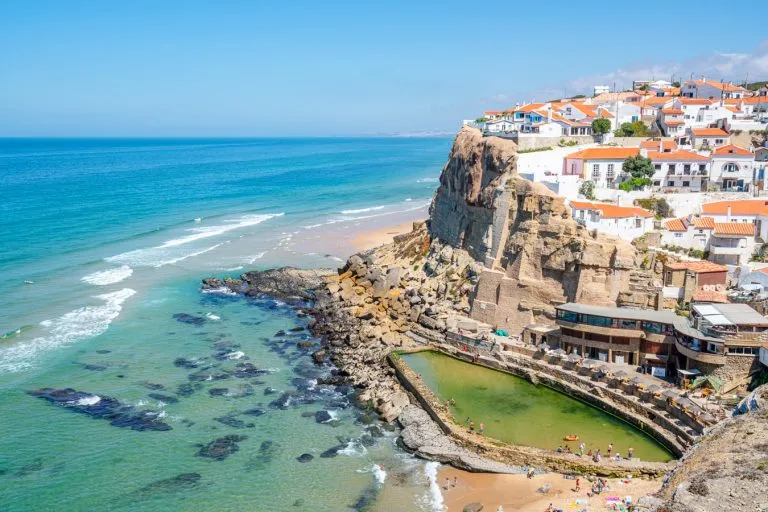 day trips to spain from lisbon photo of azenhas do mar with ocean pool visible from above, one of the best day trips from lisbon portugal