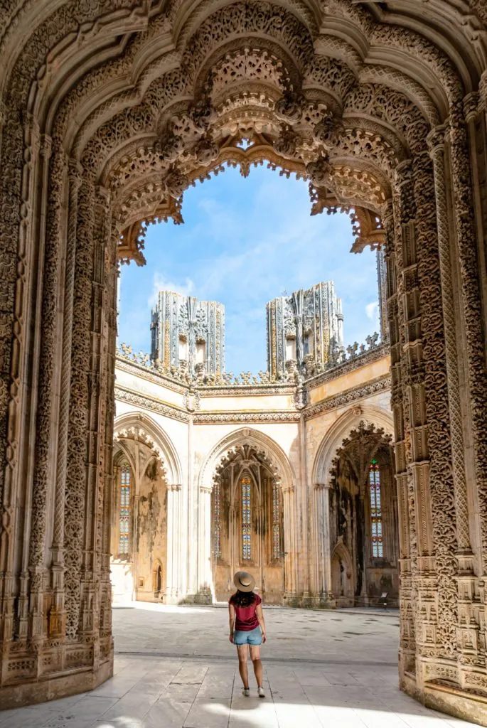 kate storm standing in the doorway to the unfinished chapels at batalha monastery portugal