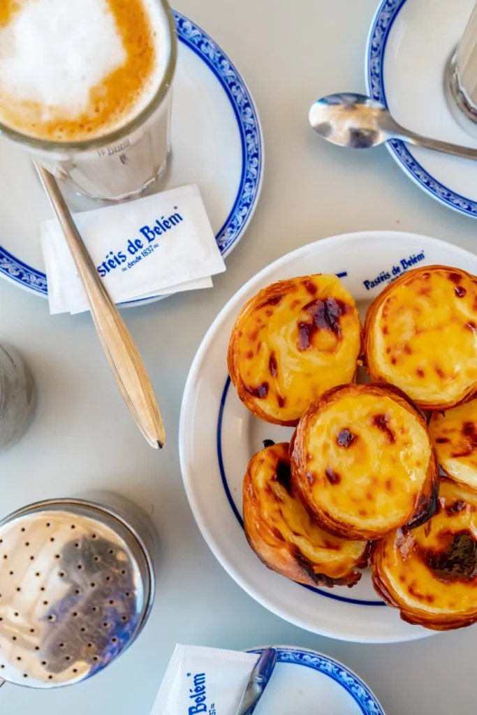 flatlay of pasteis de nata and coffee at pasteis de belem lisbon portugal