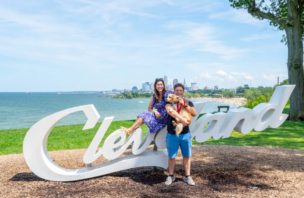 kate storm jeremy storm and ranger storm posing on the cleveland sign at edgewater park during a midwest road trip itinerary