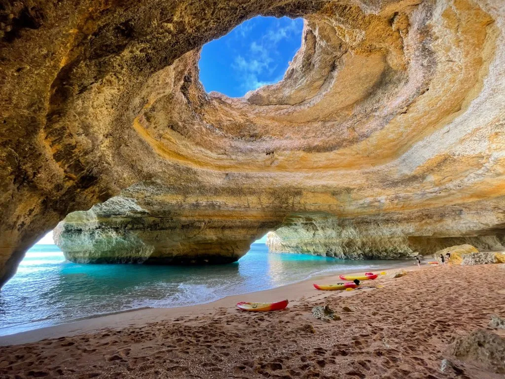 kayaks and sup boards at the edge of the beach in benagil cave algarve portugal