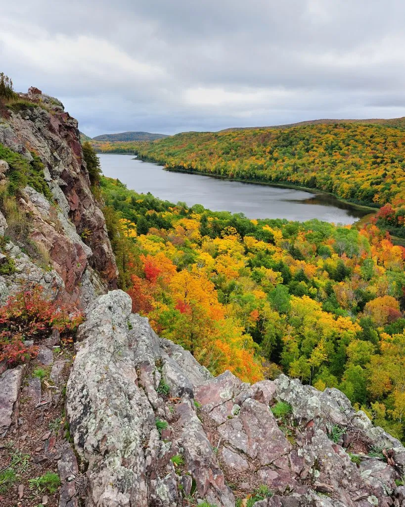 view of fall foliage and a lake in porcupine wilderness state park, one of the best stops on a michigan road trip midwest itinerary