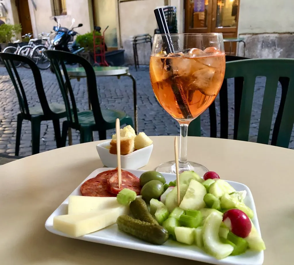 aperitivo in rom with spritz in the background and snacks in the foreground