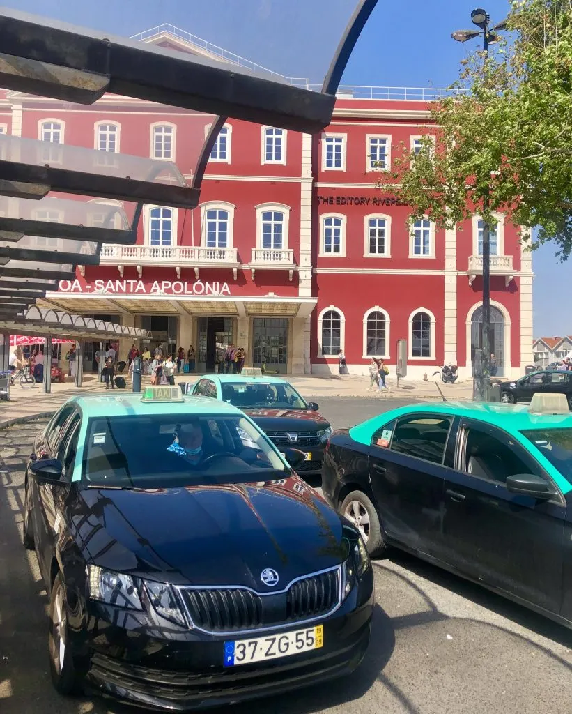 group of taxis parked in front of lisbon santa apolonia train station