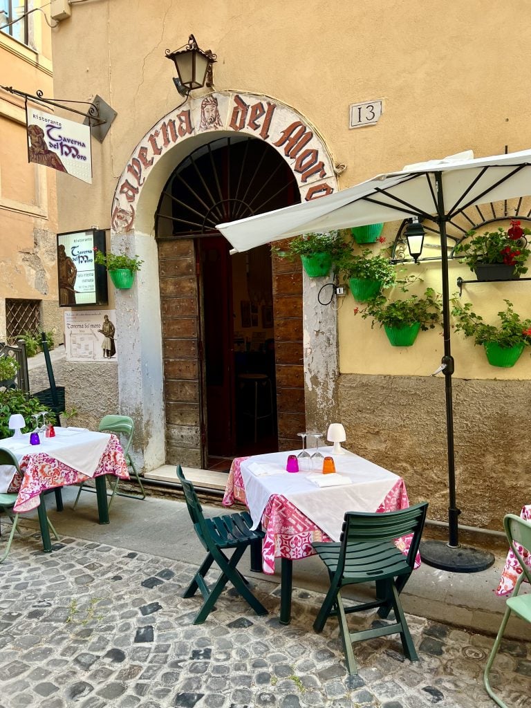 front facade of a restaurant in civitavecchia italy with tables set out for dinner