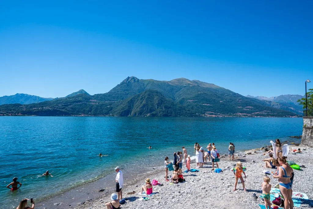 visitors enjoying a small beach in varenna lake como in summer