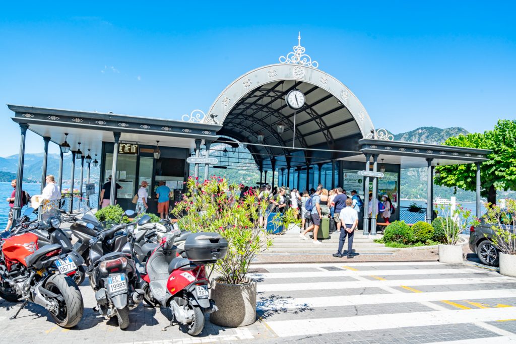 travelers standing in line waiting to board a ferry in bellagio italy