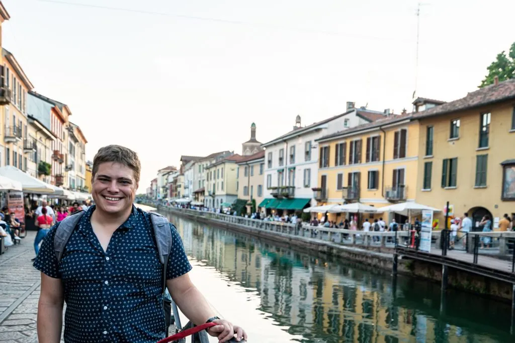 jeremy storm standing along a canal in the navigli district as part of a milan itinerary