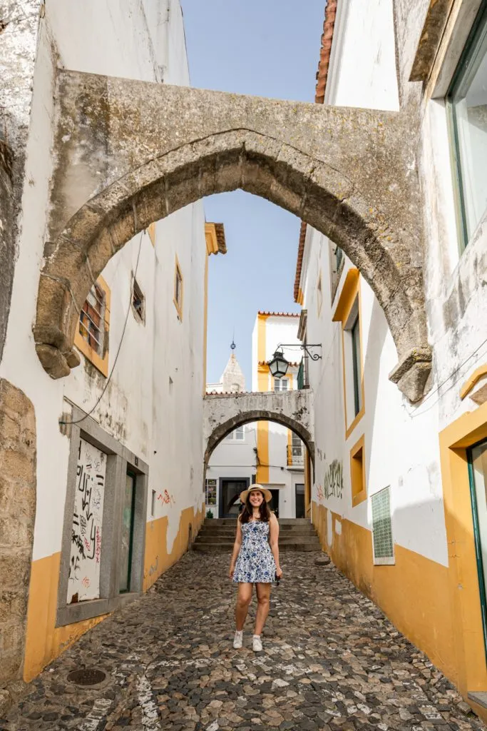 kate storm under and arch with yellow and white walls in evora portugal