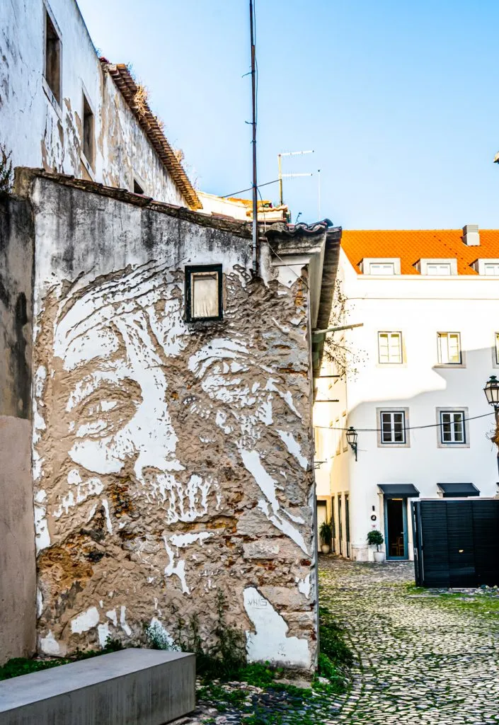 street art portrait by vhils in alfama lisbon