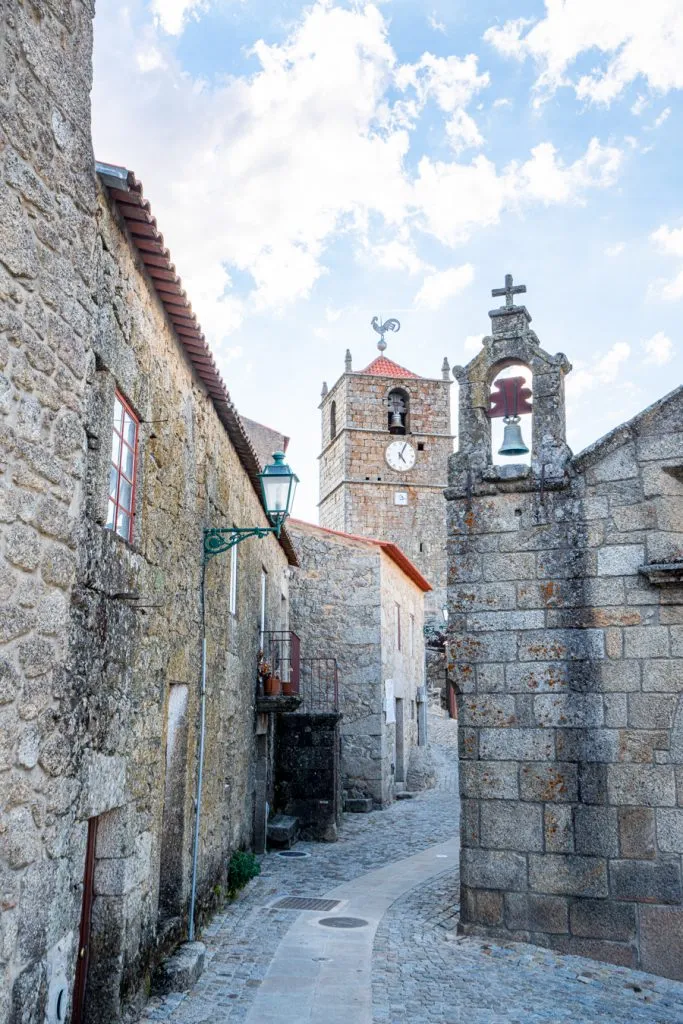 view of a small stone street as seen when visiting monsanto portugal with lucano tower in the center