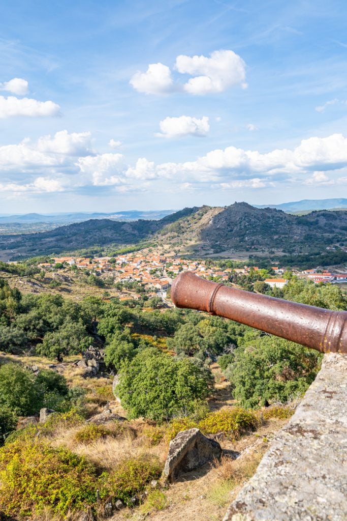 view of a cannon perched above a valley as seen when visiting monsanto portugal