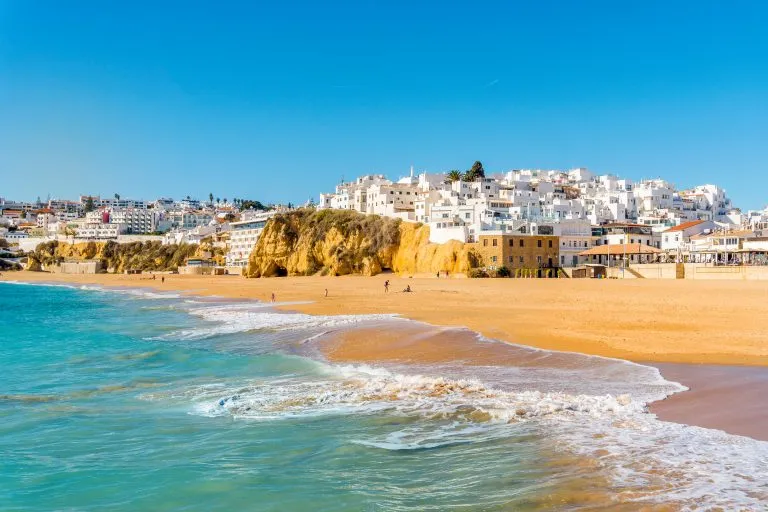 sandy beach in albufeira portugal as seen from the water, one of the best beach towns in portugal to visit