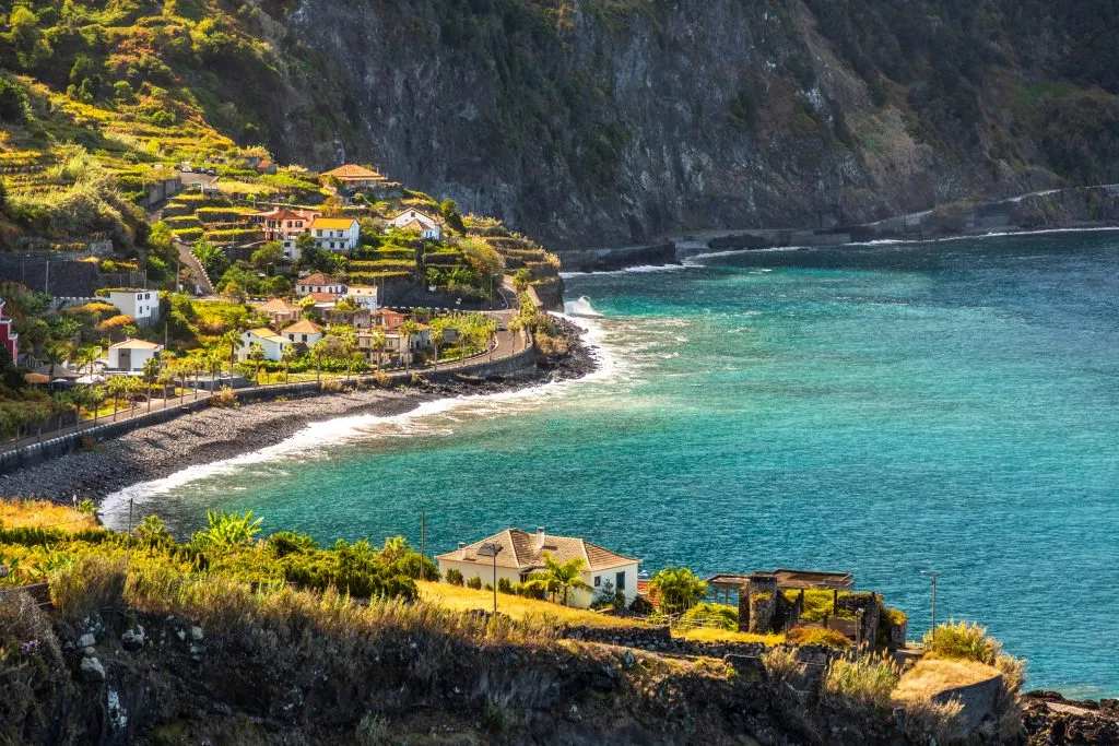 porto moniz in the summer as seen from a distance with both water and land in the foreground
