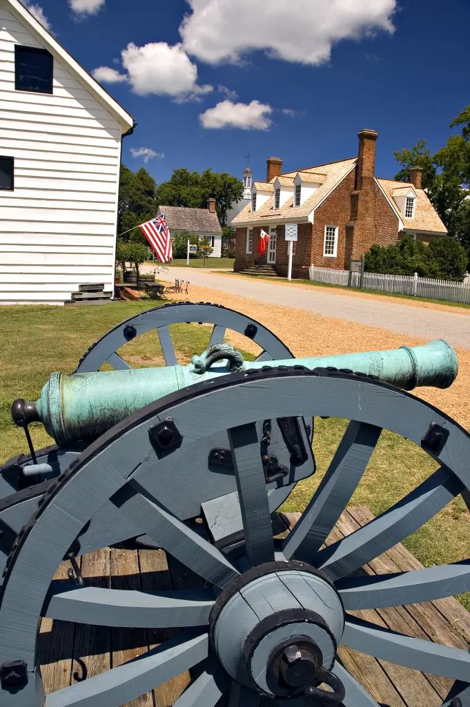 antique cannon in yorktown virginia with historical buildings in the background