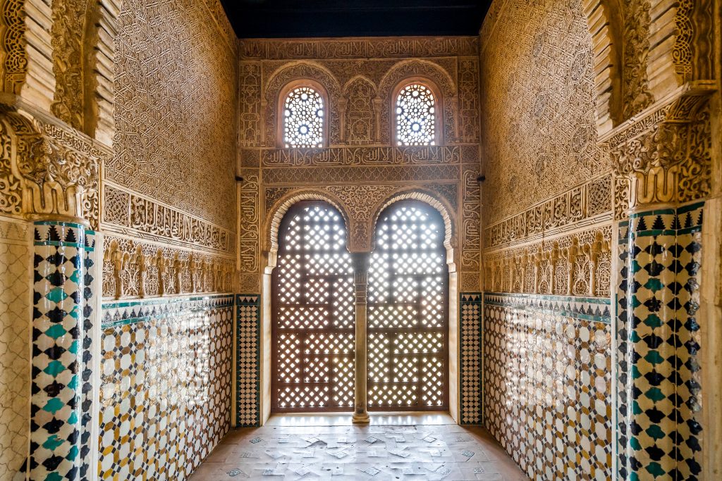 interior of tiled and decorated room in nasrid palaces, as seen on tour alhambra granada