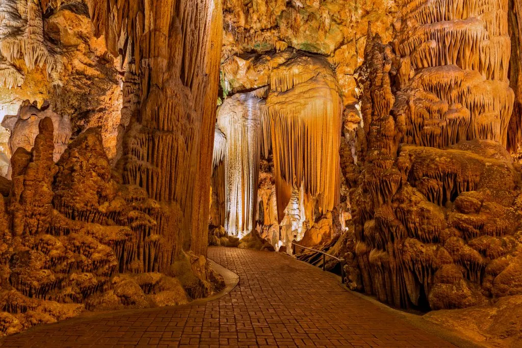 stalactites and stalagmites in luray caverns virginia with a paved path leading through the formations