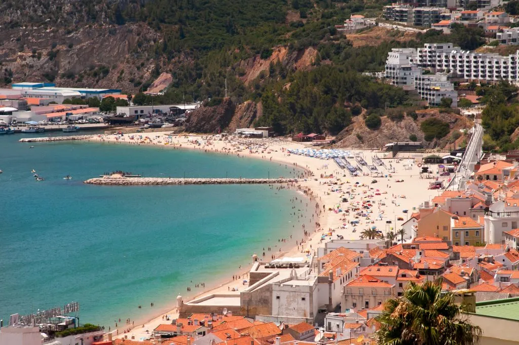 sesimbra portugal beach town as seen from above, with ocean to the left. sesimbra is one of the best coastal towns in portugal to visit