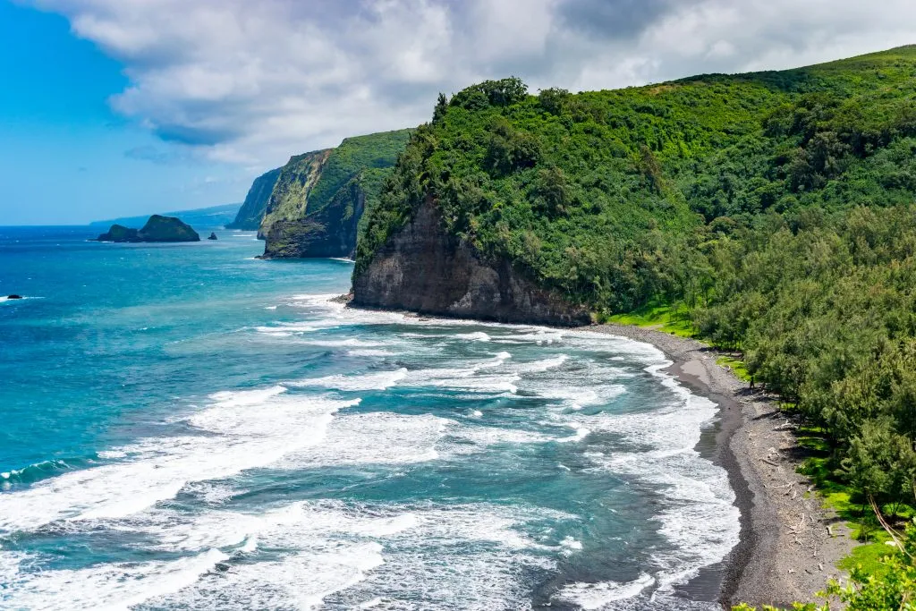 dramatic coastline of big island hawaii with beach in the foreground, one of the best warm winter vacations in usa