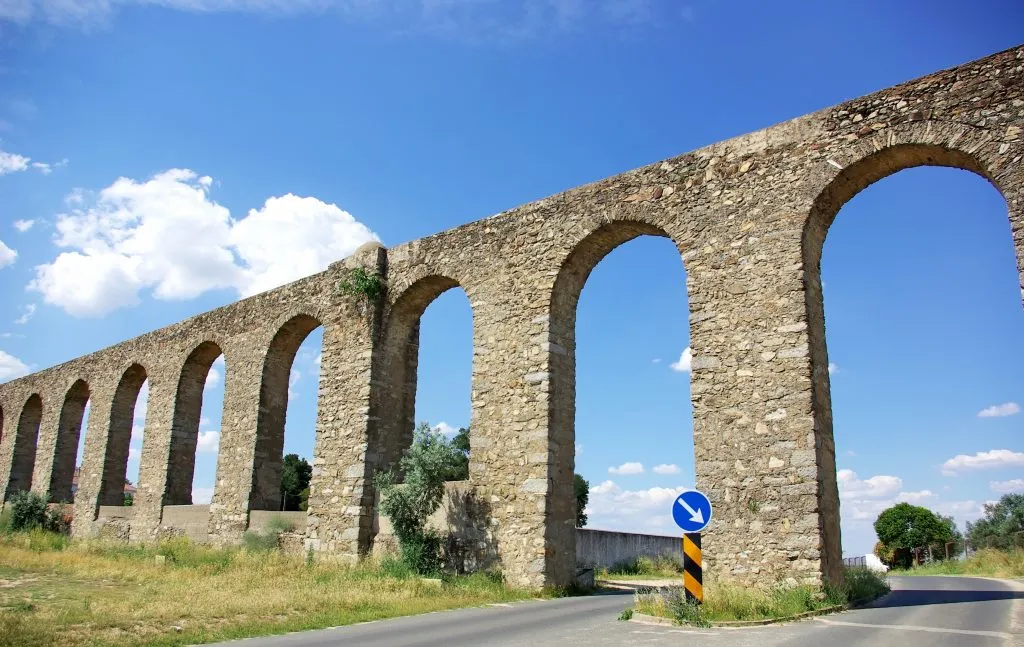 evora portugal aqueduct with paved road running underneath it