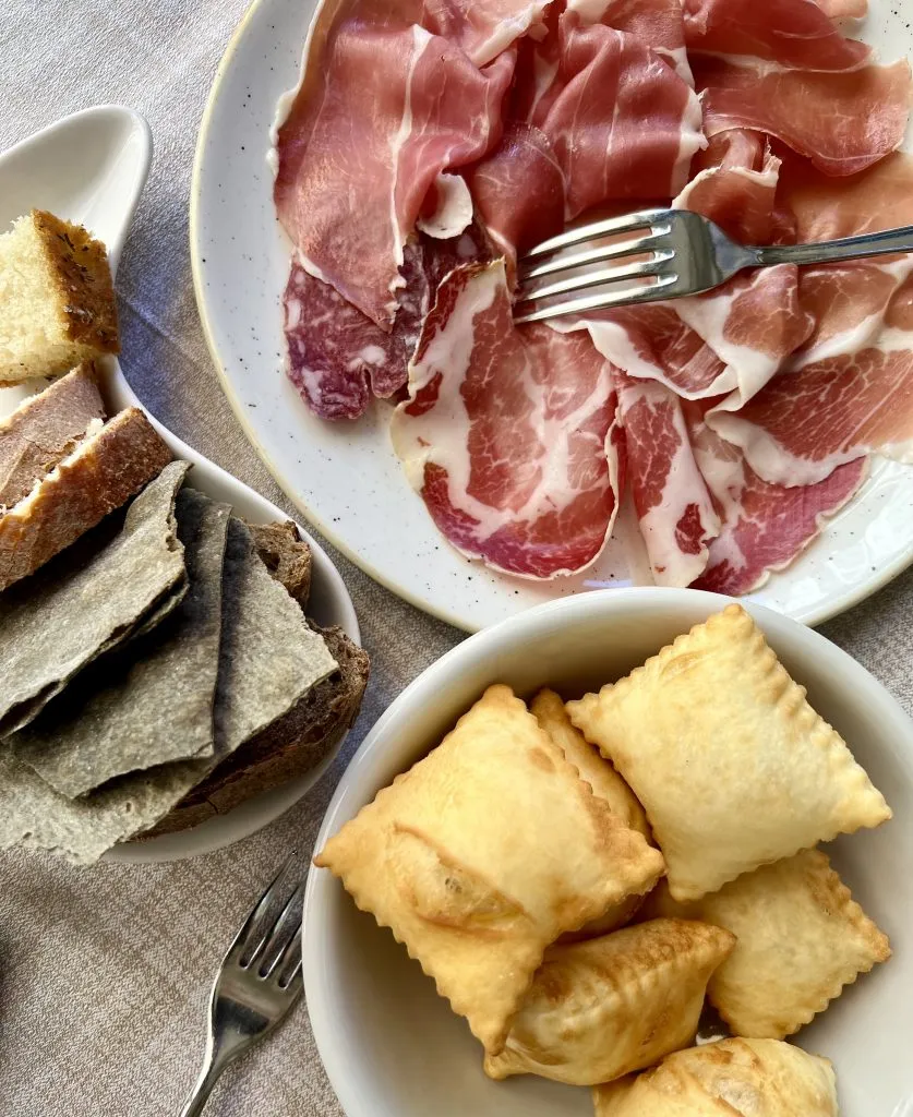 cured meat and torta frita served at restaurant parma italy
