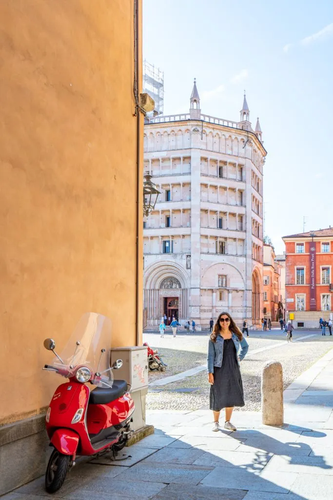 kate storm visiting parma italy with baptistery in the background and red vespa in the foreground