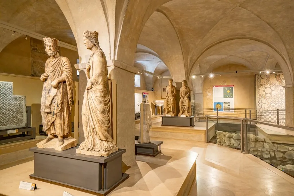 interior of diocesan museum in parma italy with 2 statues in the foreground