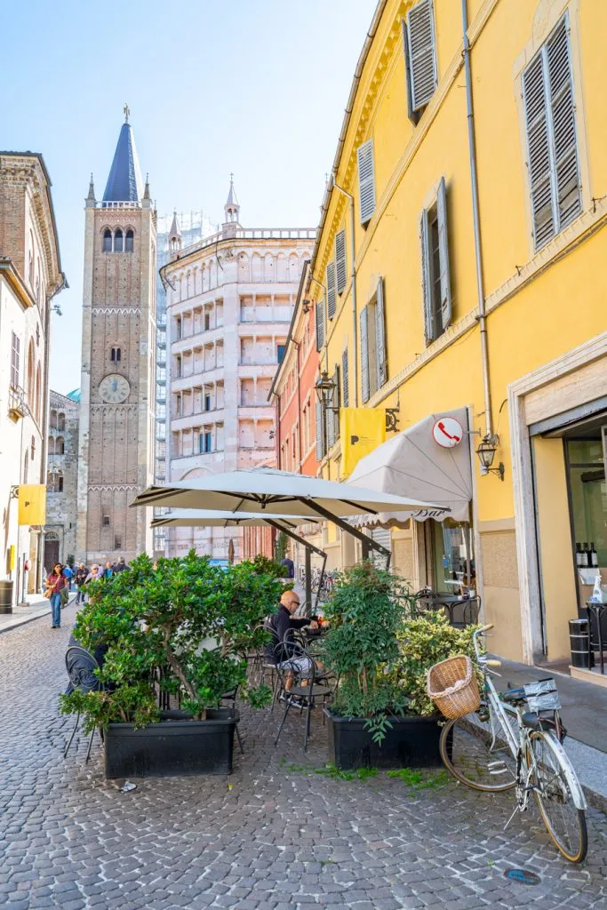 street scene during a visit parma with baptistery and clock tower in the background