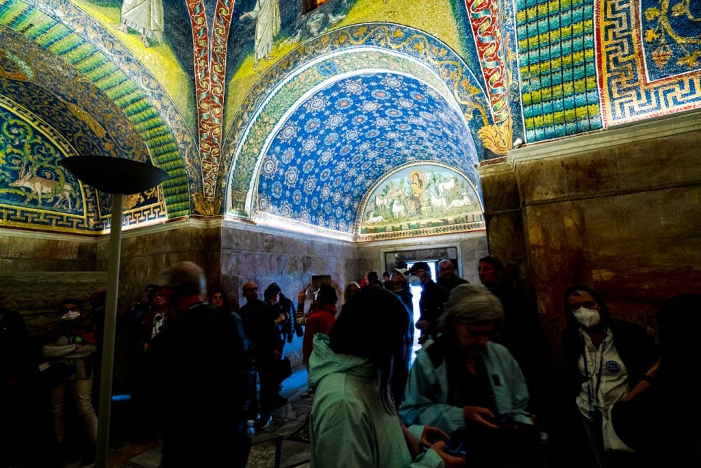 crowd of people visiting the dark Mausoleum of Galla Placidia